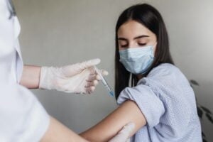 The doctor injects the vaccine to the girl