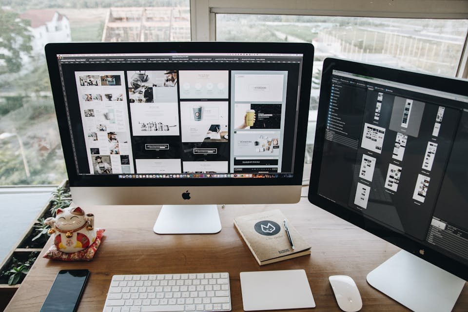 A well-organized workspace showcasing dual Apple iMacs on a wooden desk ideal for design and productivity.