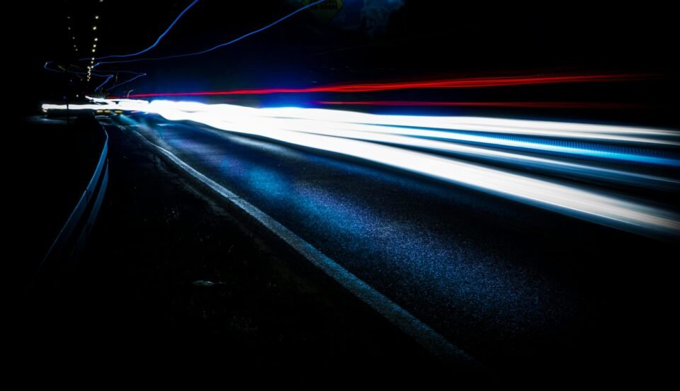 Long exposure shot of vibrant light trails on a highway at night, showing urban motion and speed.